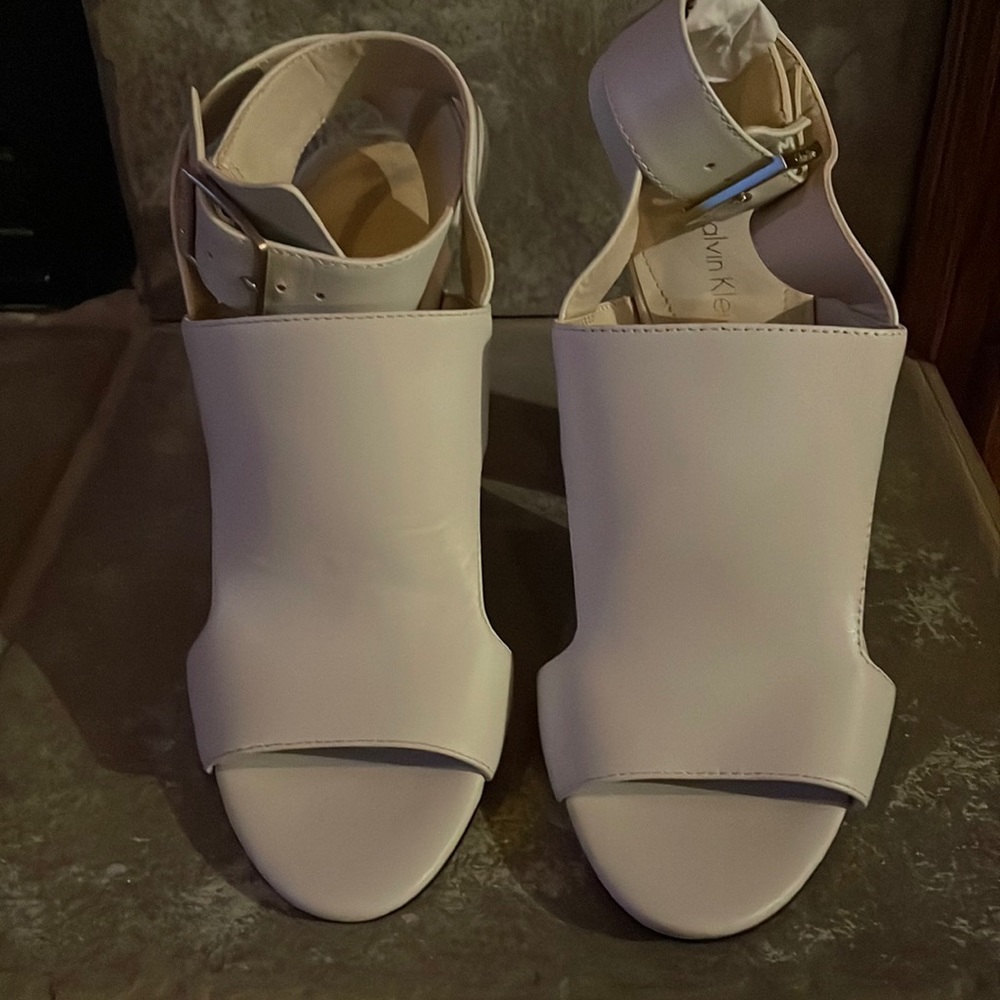 Calvin Klein Ivory Leather peep toe sandal with gold hardware.